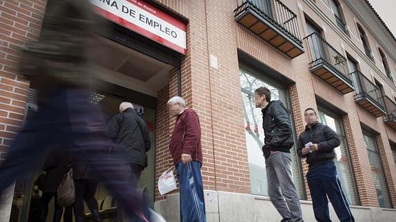 Varias personas acceden a una oficina de empleo. 