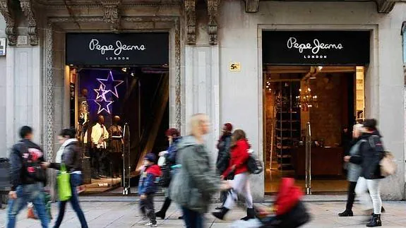 Varios viandantes caminan junto a una tienda de Pepe Jeans en Barcelona.