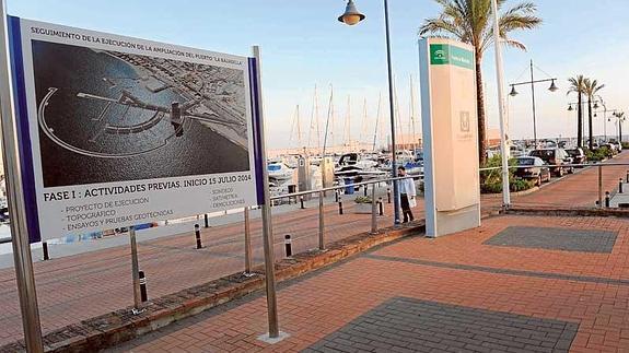 Cartel anunciando la ejecución de trabajos preliminares el pasado verano en el puerto.