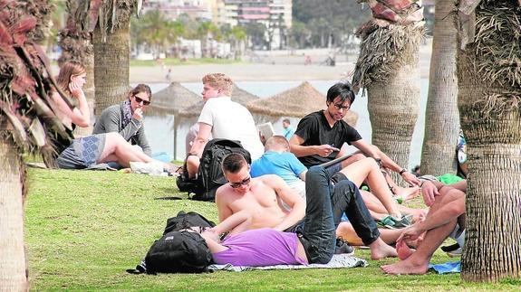 Un grupo de jóvenes, ayer, tomando el sol a orillas del mar en La Malagueta. 