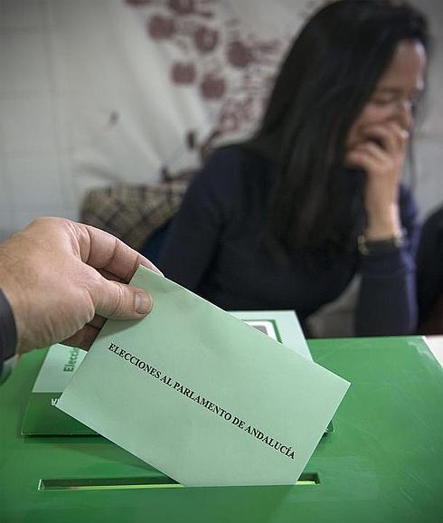 Un votante introduce su papeleta en la urna. 