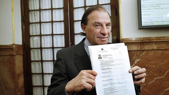 Vicente Martínez Pujalte muestra a los fotógrafos su declaración de bienes y rentas, tras ser acusado de «uso indebido» de su condición de diputado. 