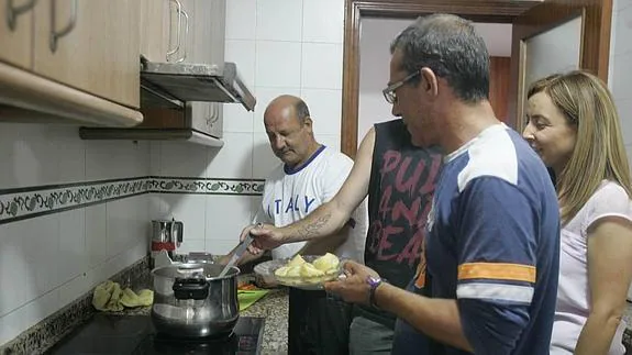 Gabriel, Ángel y José Miguel ultiman en la cocina el guiso de lentejas que toca para comer. 