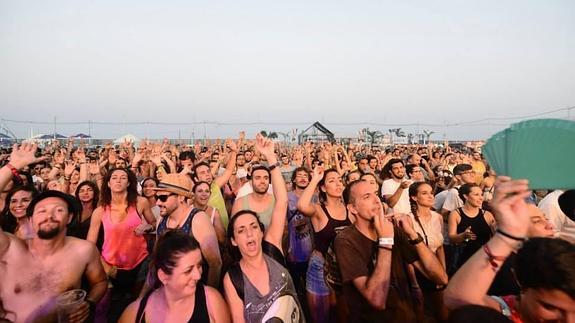 Asistentes al festival con la playa al fondo. 