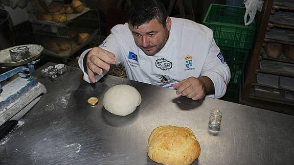 Moreno espolvorea el oro comestible sobre la masa, que lleva también el metal en polvo.