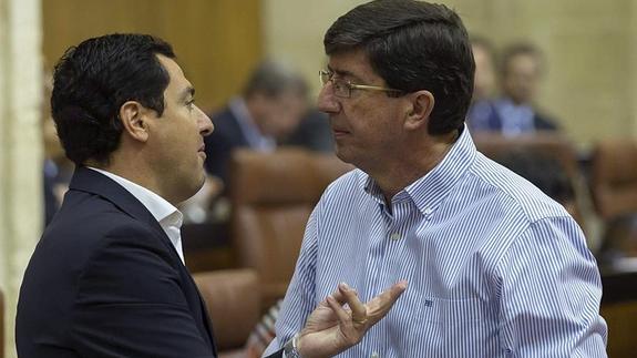 Juanma Moreno y Juan Marín conversan en el Pleno del Parlamento ayer.