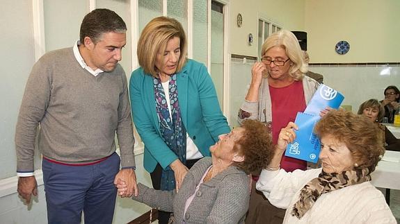 Fátima Báñez y Elías Bendodo han participado en una merienda con mayores. 