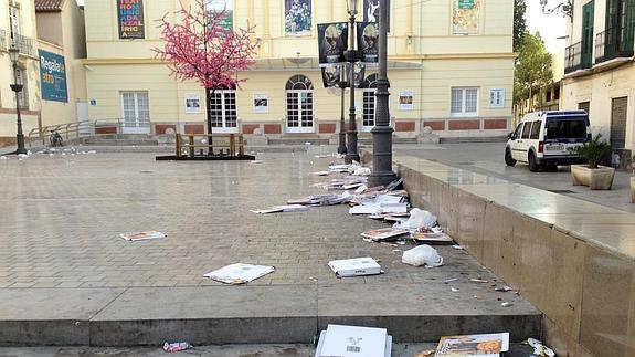 Vista de la plaza con los restos de cartones de pizza y demás desechos esparcidos por el suelo. 