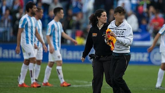El joven aficionado abandona el césped con la camiseta de Messi. 