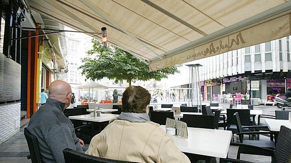 Natalia, en una terraza del Centro, acompañada de uno de sus hijos.