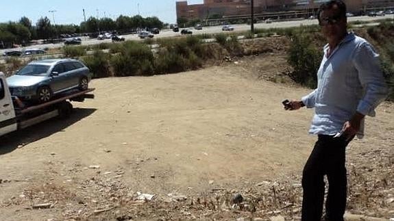 Luis Asenjo, al pie del terraplén por donde cayó su automóvil mientras la grúa se lo lleva al taller.