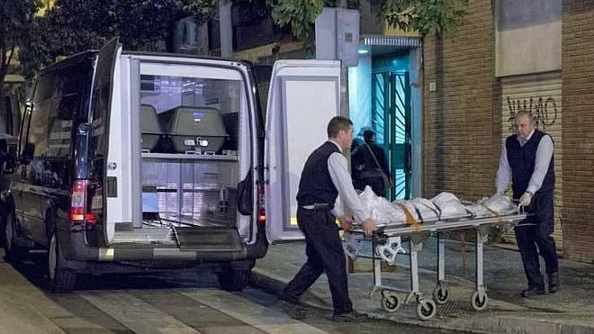 Los servicios funerarios trasladan el cadáver de la mujer fallecida.