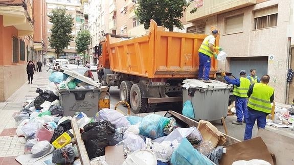 Operarios de la empresa contratada por el Ayuntamiento retiran los residuos acumulados en la calle Blanco Coris. 
