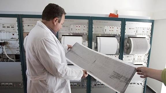 Un experto analiza la gráfica de un terremoto.