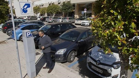 Un conductor inserta las monedas en un parquímetro de la capital tras estacionar su vehículo. 