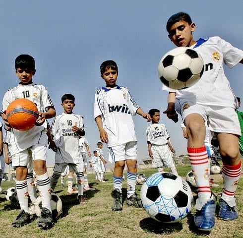 Niños iraquíes vestidos con la equipación del Real Madrid entrenan en una escuela de fútbol en Bagdad, la capital de Irak. 