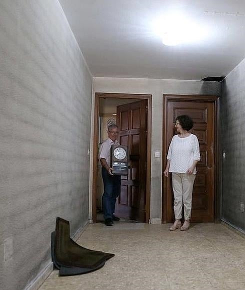 Una familia saca enseres de su casa que ha quedado inutilizada por el fuego.