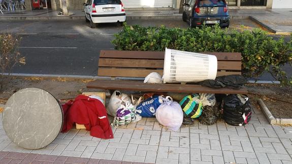 Banco en la calle Tomás Echeverría, con numerosas bolsas y todo tipo de enseres. 