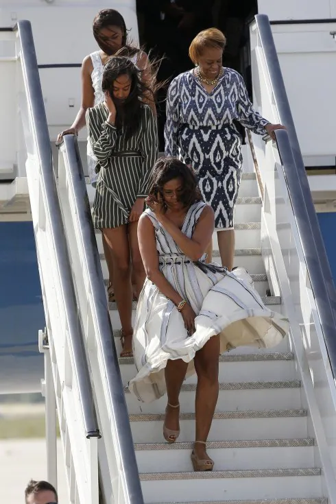 El viento estuvo a punto de jugarle una mala pasada a Michelle Obama, que llegó a Madrid con sus hijas  y su madre. Sobre estas líneas, la primera dama y la Reina, en los jardines de la Casa Blanca. :: efe