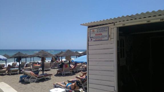 Parcela de hamacas en Fuengirola y el cartel que prohíbe la actividad comercial. 