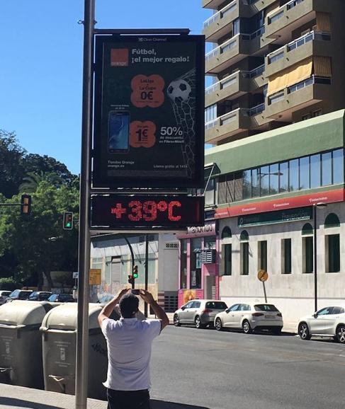 Un peatón fotografía un termómetro urbano ayer en Málaga. 