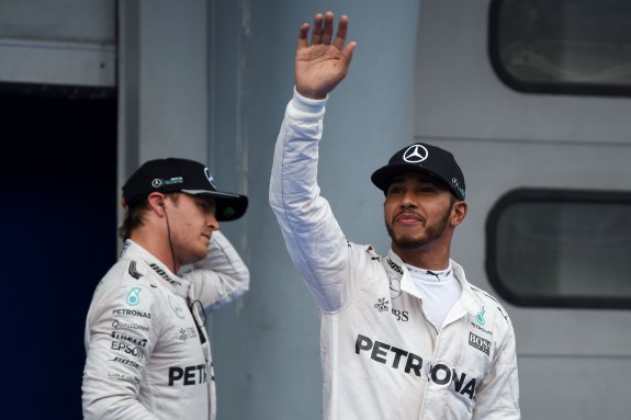 Los mecánicos ayudan a Lewis Hamilton a llevar su Mercedes hasta los garajes. :: MOHD RASFAN. AFPHamilton saluda junto a Rosberg. :: MOHD RASFAN. AFP