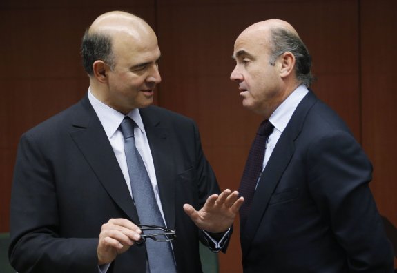 El comisario europeo Pierre Moscovici charla con el ministro Luis de Guindos. :: FRANCOIS LENOIR / reuters