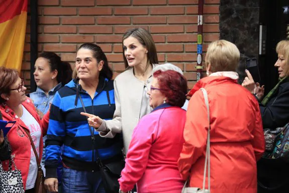 Doña Letizia es recibida por los vecinos a las puertas de la sede de la Confederación Salud Mental España, en Entrevías. :: AFP