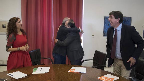 Montero y Marín observan el abrazo entre Juan Cornejo (PSOE) y Manuel Bruzón (C’s) tras la firma.