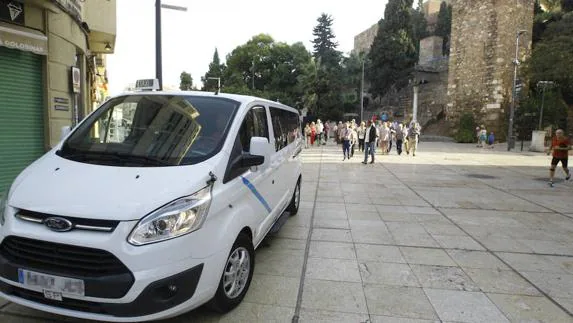 Un taxi de nueve plazas se adentra por la calle Císter, en el Centro de Málaga. 