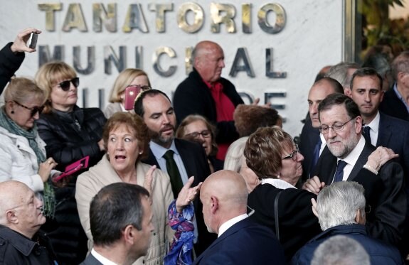 Una mujer abraza a Mariano Rajoy a la salida del tanatorio. :: Manuel Bruque / efe