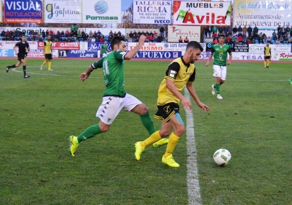 Kike Márquez avanza con el balón perseguido por un jugador del Villanovense. :: optasports