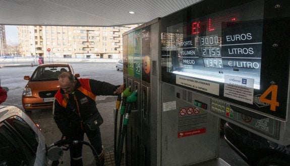 Un empleado de una gasolinera llena el depósito de un automóvil. :: diaz uriel