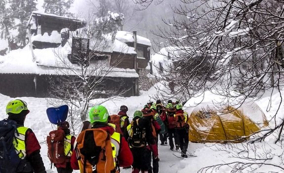 Varios voluntarios del servicio de rescate de montaña Socorro Alpino se dirigen a continuar las labores de búsqueda de víctimas. :: Efe

