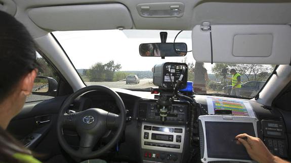 Agentes de la Guardia Civil, en un control de velocidad con un radar móvil en una carretera secundaria. 