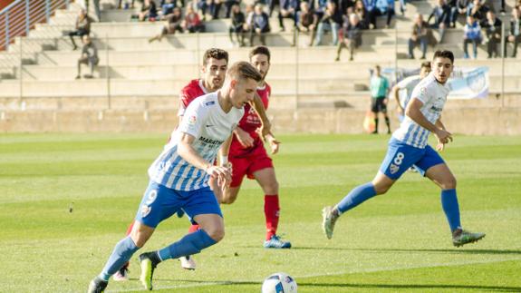 Wojcik conduce el balón, con Castillo más adelantado. 