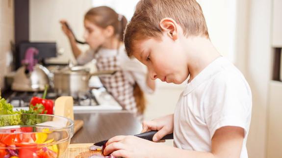 Un niño preparando la comida con su hermana