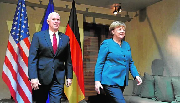 Pence y Merkel abandonan la sala en la que todos los mandatarios asistentes posaron para la fotografía oficial de la Conferencia de Seguridad. ::  Christof STACHE / afp