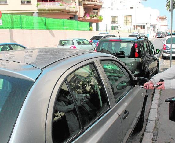 Una vecina trata sin éxito de cerrar su vehículo con el mando a distancia.