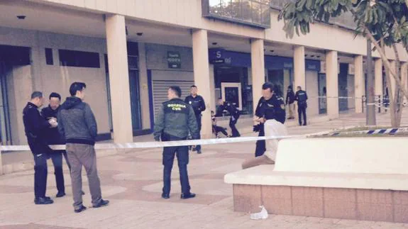 El detenido, sentado junto a un agente, mientras un policía asiste a la víctima, ayer en la avenida de Andalucía.