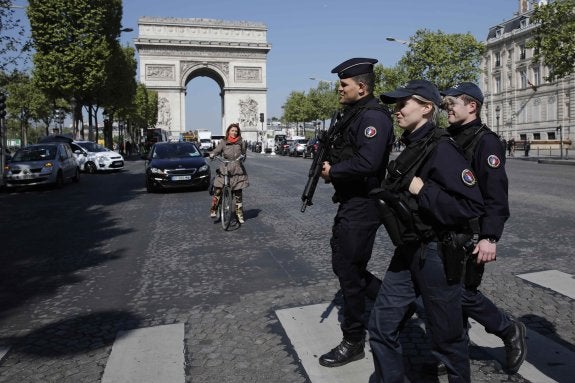 Policías armados patrullan por los Campos Elíseos, muy cerca del Arco del Triunfo.