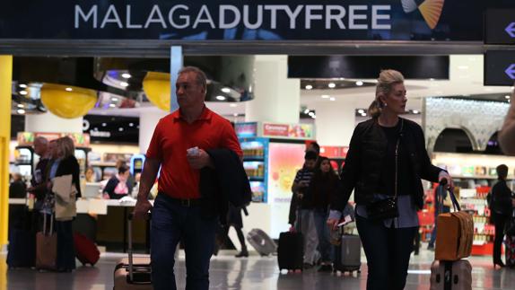 Pasajeros atraviesan la tienda principal libre de impuestos del aeropuerto de Málaga.