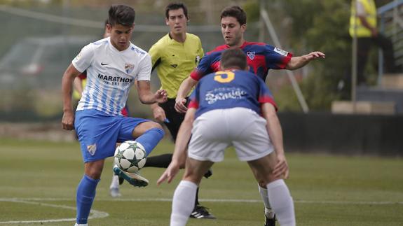 Kuki, que golpea el balón ante la presión de dos rivales, fue el autor del gol del Malagueño.