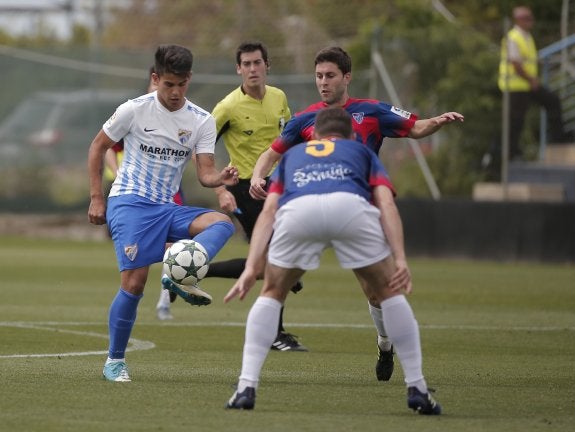 Kuki, que golpea el balón ante la presión de dos rivales, fue el autor del gol del Malagueño. :: ñito salas