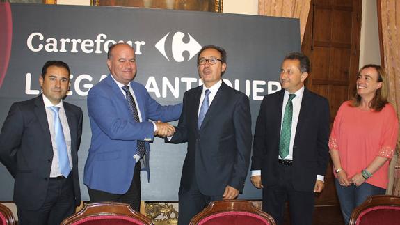 El alcalde Manuel Barón estrechando la mano del director regional Arturo Montalvo, flanqueado por el gerente de Carrefour Antequera José Luis Alba y la teniente de alcalde de Comercio Belén Jiménez