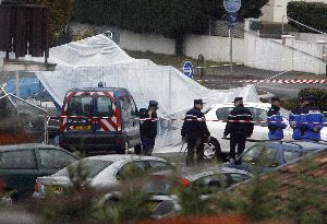 VIGILANCIA. Policías franceses controlan el vehículo que se encuentra cubierto y que fue el que utilizaron los etarras en su huida tras cometer                                   el asesinato del guardia civil. / EFE