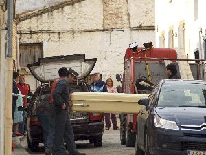 CONSTERNACIÓN. Empleados de una funeraria trasladan el cuerpo sin vida de la mujer encontrada muerta en la bodega de su casa. / EFE