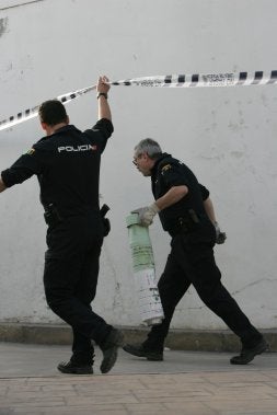 Un agente retira el proyectil hallado en La Araña. / C. MORET