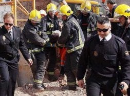 Un grupo de bomberos evacua a uno de los heridos. / SALVADOR SALAS