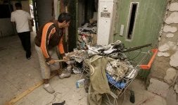 Del cuarto de contadores sacan con palas la basura, que llegaba casi al techo. Al portal le faltan los mosaicos. / ANTONIO SALAS